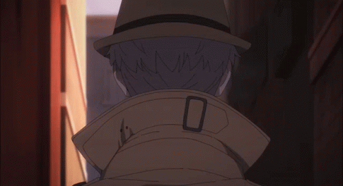 A Man Wearing A Hat And A Trench Coat Has The Letter O On The Collar GIF