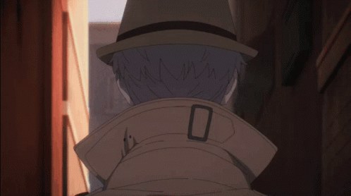 A Man Wearing A Hat And A Trench Coat Has The Number 0 On The Collar GIF