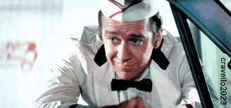 A Man Wearing A Hat And Bow Tie Is Looking Out Of A Car Window With The Words Craveler2023 On The Bottom GIF