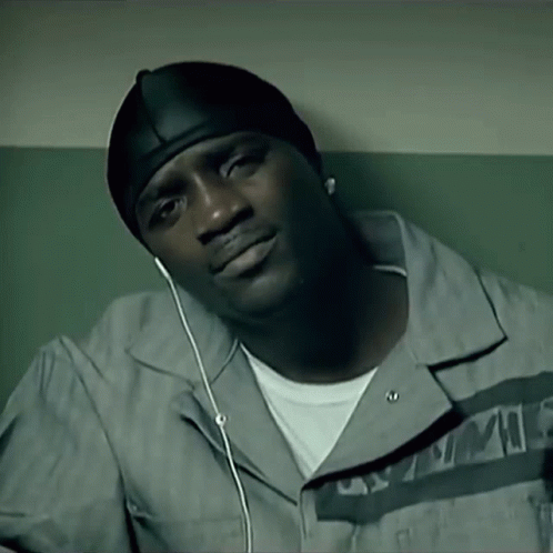 A Man Wearing A Hat And Ear Buds Is Listening To A Song GIF