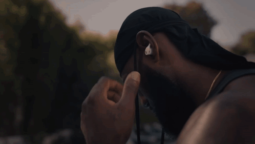 A Man Wearing A Hat And Ear Buds With The Letter O On It GIF