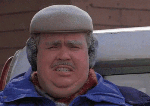 A Man Wearing A Hat And Ear Muffs Is Making A Face GIF