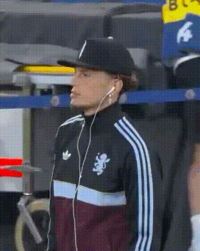 a man wearing a hat and earbuds is wearing an adidas jacket