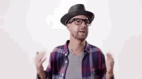 A Man Wearing A Hat And Glasses Is Talking To Someone . GIF