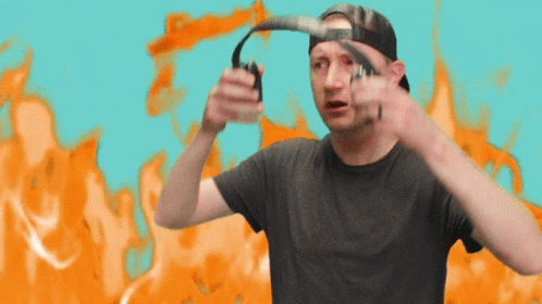 A Man Wearing A Hat And Headphones Is Standing In Front Of An Orange Background GIF