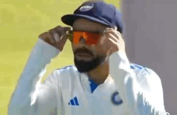 A Man Wearing A Hat And Sunglasses Is Adjusting His Glasses . GIF