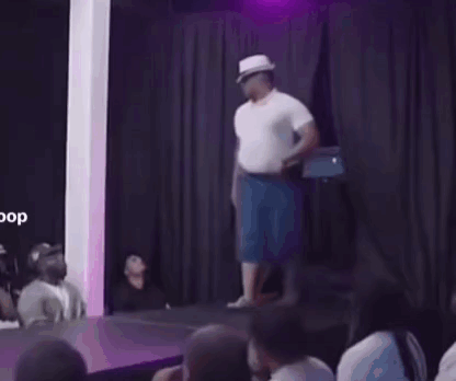 A Man Wearing A Hat And Sunglasses Is Dancing In A Room . GIF