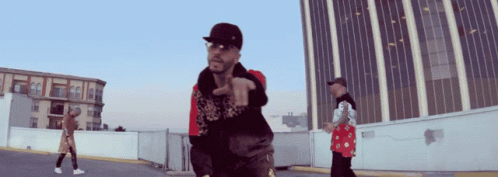A Man Wearing A Hat And Sunglasses Is Pointing GIF