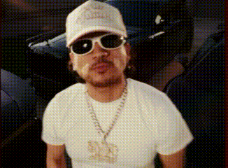 A Man Wearing A Hat And Sunglasses Is Standing In Front Of A Car .. GIF