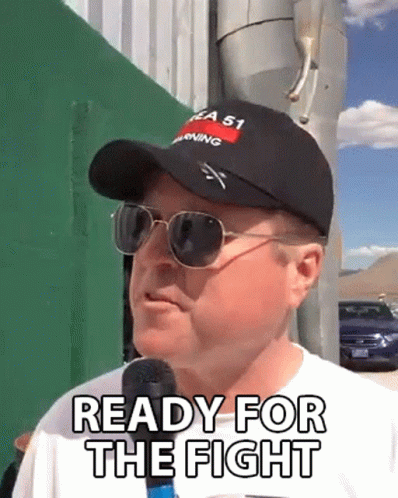 A Man Wearing A Hat And Sunglasses Is Talking Into A Microphone And Saying Ready For The Fight . GIF