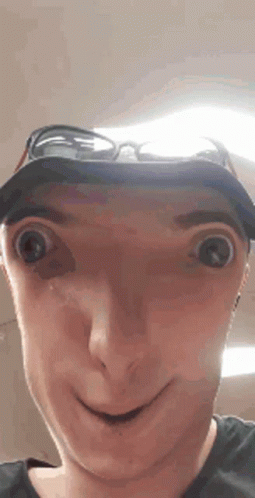 A Man Wearing A Hat And Sunglasses Making A Funny Face . GIF