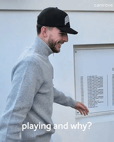 A Man Wearing A Hat And Sweater Is Standing In Front Of A Sign That Says " Playing And Why " GIF