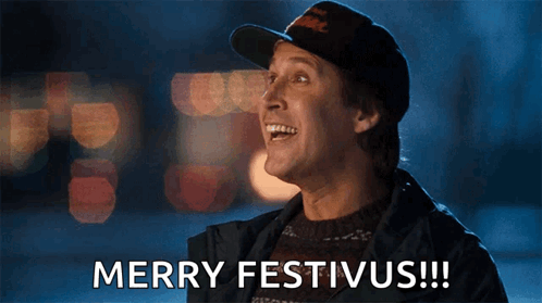 A Man Wearing A Hat And Sweater Says Merry Festivus !!! GIF