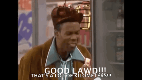 A Man Wearing A Hat And Tie Is Holding A Candy Bar And Says Good Lawd !!! GIF