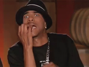 A Man Wearing A Hat Is Biting His Nails And Making A Funny Face . GIF