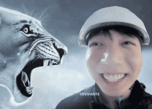 A Man Wearing A Hat Is Smiling In Front Of A Lion GIF