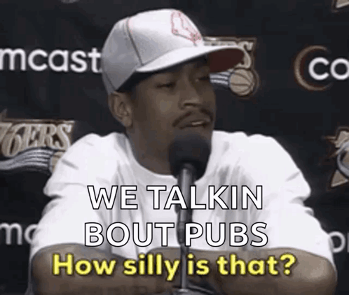 A Man Wearing A Hat Is Talking Into A Microphone And Says We Talkin Bout Pubs How Silly Is That . GIF