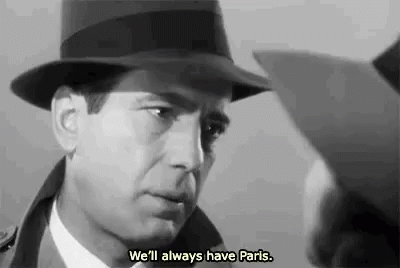 a man wearing a hat is talking to another man in a black and white photo .