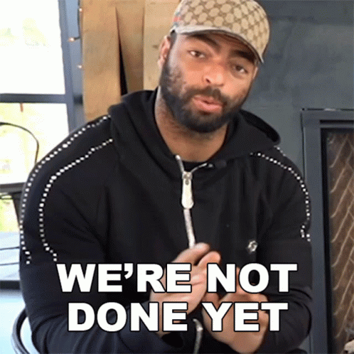 A Man Wearing A Hat Says " We 'Re Not Done Yet " In Front Of A Fireplace GIF