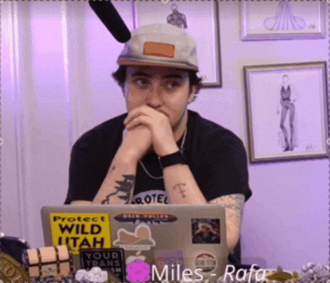 A Man Wearing A Hat Sits In Front Of A Laptop With Stickers On It Including One That Says Protect Wild Utah GIF