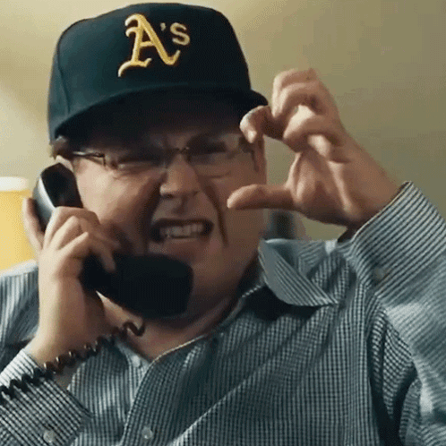 A Man Wearing A Hat That Says A 'S Is Talking On A Phone GIF