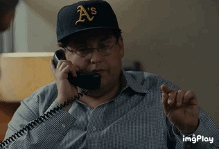 A Man Wearing A Hat That Says A 'S Is Talking On A Phone GIF