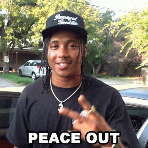 A Man Wearing A Hat That Says Damaged Goods Is Giving The Peace Sign GIF