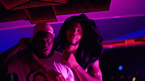 a man wearing a hat that says gucci on it stands next to another man