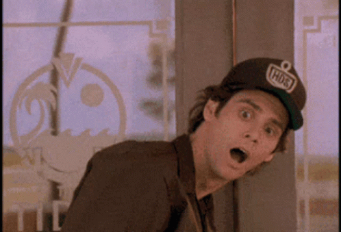 A Man Wearing A Hat That Says Hudson Is Standing In Front Of A Window GIF