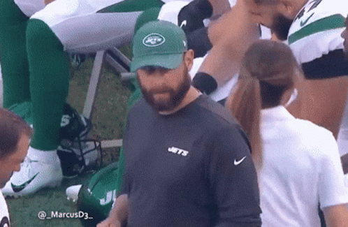 A Man Wearing A Hat That Says Jets Is Standing On A Field GIF