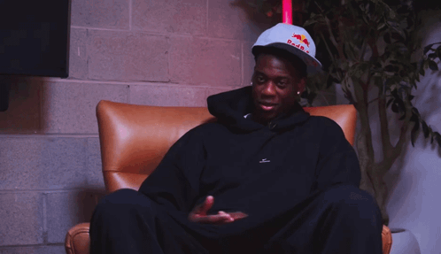 A Man Wearing A Hat That Says Red Bull On It GIF