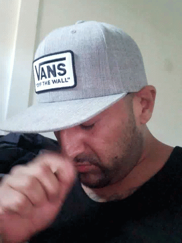 A Man Wearing A Hat That Says Vans Off The Wall GIF