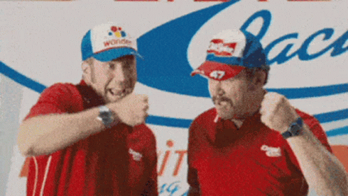 A Man Wearing A Hat That Says Wonder Stands Next To Another Man GIF