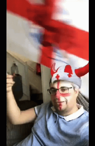 A Man Wearing A Hat With Horns And A Red Cross On It GIF