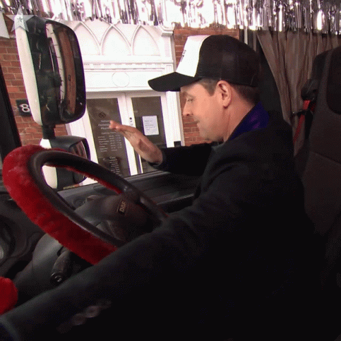 A Man Wearing A Hat With The Letter B On It Is Driving A Car GIF