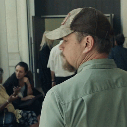 A Man Wearing A Hat With The Letter R On It Looks To His Left GIF