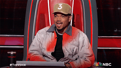 A Man Wearing A Hat With The Number 3 On It Is Sitting In A Chair GIF