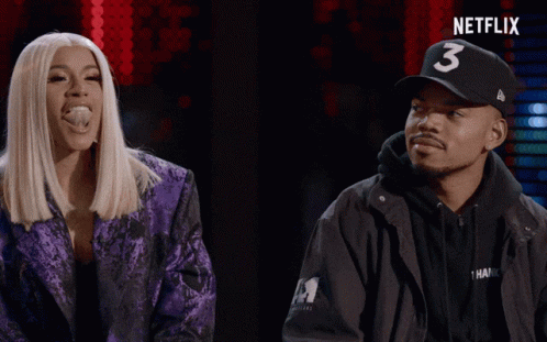 A Man Wearing A Hat With The Number 3 On It Stands Next To A Woman In A Purple Jacket GIF