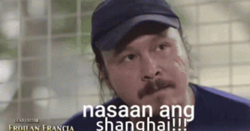 A Man Wearing A Hat With The Words Nasaan Ang Shanghai On It GIF