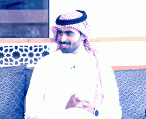 A Man Wearing A Head Scarf And A White Shirt Has A Letter T On His Shirt GIF