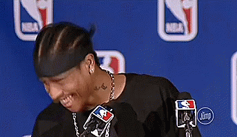 A Man Wearing A Headband And A Necklace Is Standing In Front Of A Microphone . GIF