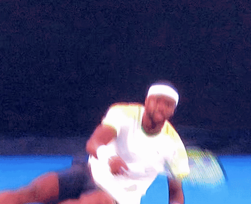 a man wearing a headband and a white shirt is playing tennis