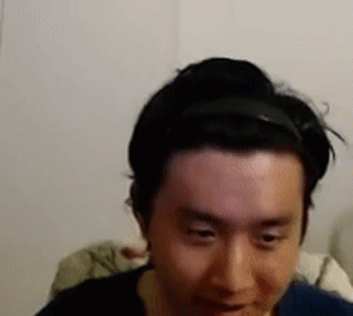 A Man Wearing A Headband Is Looking At The Camera . GIF