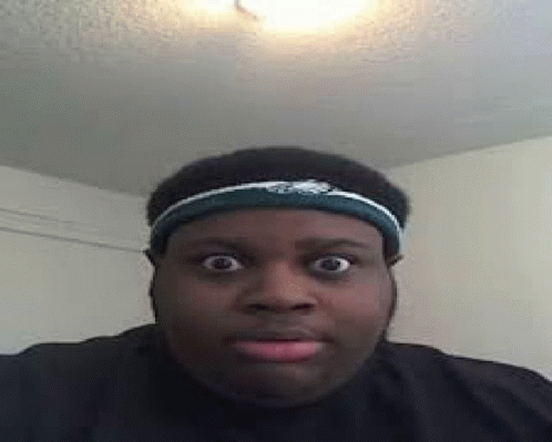 A Man Wearing A Headband Is Making A Funny Face While Looking At The Camera . GIF