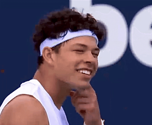A Man Wearing A Headband Is Smiling And Looking To The Side GIF