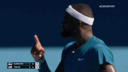 a man wearing a headband is smiling on a tennis court