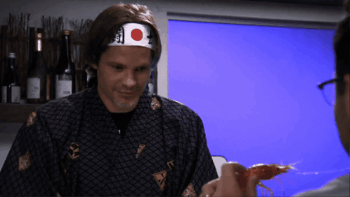 A Man Wearing A Headband With A Red And White Circle On It GIF