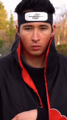 A Man Wearing A Headband With A Symbol On It Is Looking At The Camera GIF