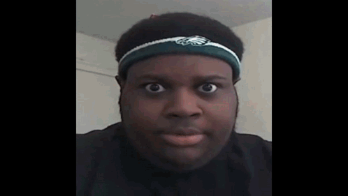 A Man Wearing A Headband With The Eagles Logo On It Looks At The Camera . GIF