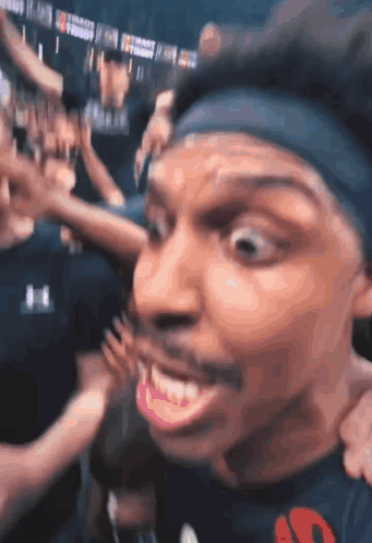 A Man Wearing A Headband With The Letter S On It Is Smiling GIF
